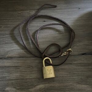 Lv lock w key on leather strap wear as a choker or wrap around your wrist